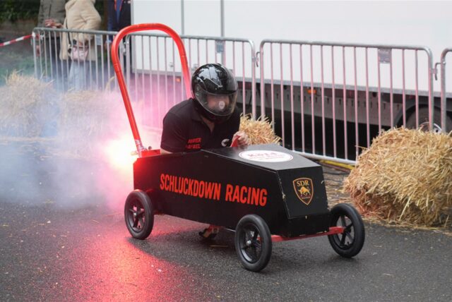 Eine Seifenkiste in Form eines Feuerlöschers wird auf die Startrampe gebracht.