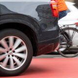 Zwischen zwei Autos kann man das Hinterrad eines Fahrrads sehen.