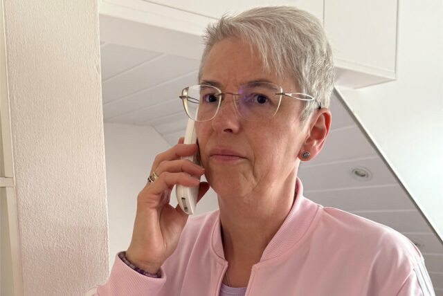 Angelika Witzorky hat einen Telefonhörer in der Hand und guckt ernst in die Kamera.