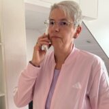 Angelika Witzorky hat einen Telefonhörer in der Hand und guckt ernst in die Kamera.