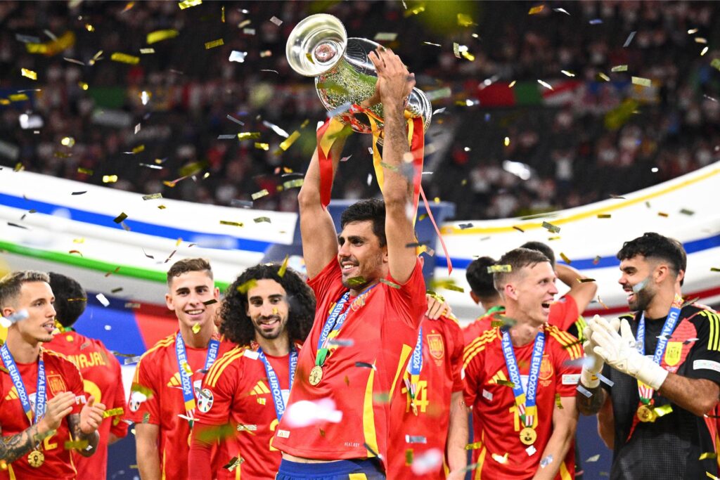 Rodri jubelt nach dem Sieg von Spanien im Finale der EM 2024 mit dem EM-Pokal. Rodri jubelt nach dem Sieg von Spanien im Finale der EM 2024 mit dem EM-Pokal.