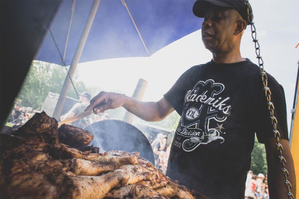 Ein Mann grillt Fleisch auf einem Festival. Ein Mann grillt Fleisch auf einem Festival.