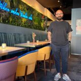 Can Korkmaz, ein Mann mit Bart und Brille, steht in seinem Restaurant.