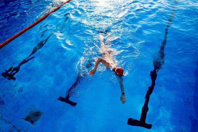 Ein Schwimmer im Wasser eines Hallenbads.