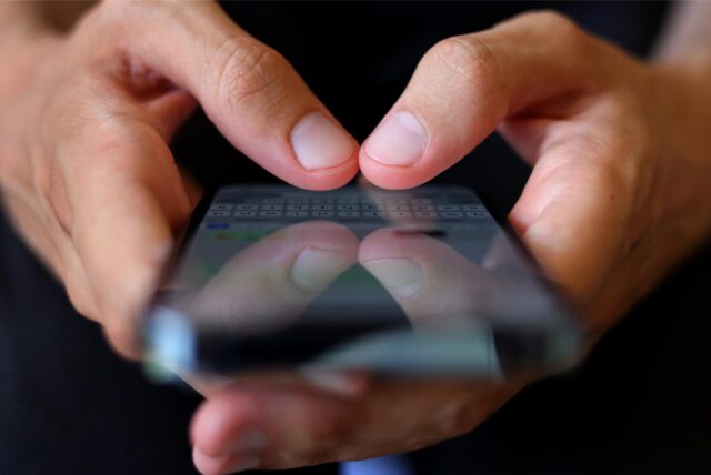 Zwei Hände halten ein Smartphone.
