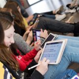 Einige Schülerinnen haben ein iPad auf den Knien. Sie bearbeiten Mathematik-Aufgaben.