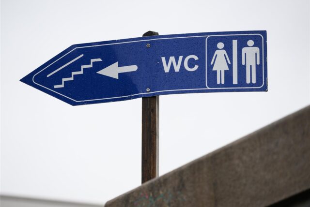 Symbolbild: Ein Schild zeigt den Weg zur nächsten öffentlichen Toilette an.