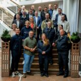 Im Dortmunder Rathaus hat die Auftaktveranstaltung eines neuen Notfallversorgungs-Projekts der Feuerwehr stattgefunden. Die Teilnehmer stehen auf einer Treppe im Eingangsbereich des Rathauses.