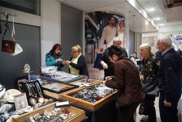 Kunden stehen um einen Stand und begutachten Schmuck.