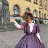 Stadtführerin Brigitte Wefringhaus steht im Biedermeier-Kostüm vor dem Rathaus in Recklinghausen.