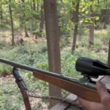 Ein Jäger hält ein Gewehr.