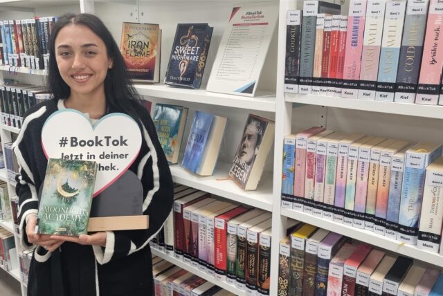 Jale Baysan, Mitarbeiterin der Stadtbibliothek Recklinghausen, vor einem Regal mit BookTok-Titeln.
