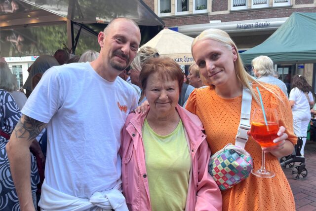 Menschen stehen auf der Kranzplatte, eine Frau hält einen Aperol in der Hand.