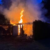 Flammen schlagen aus einer brennenden Gartenhütte.
