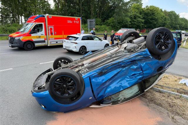 Ein blauer Opel Adam liegt nach einem Unfall auf dem Dach.