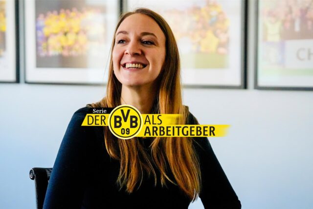 Rebecca Collmann, die die Auswärtsfahrten des BVB organisiert, vor Fotos von Erfolgen aus der Vereinsgeschichte.