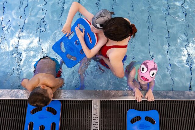 Blick ins Becken eines Hallenbades: Kinder nehmen an einem Schwimmkurs teil.