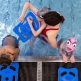Blick ins Becken eines Hallenbades: Kinder nehmen an einem Schwimmkurs teil.