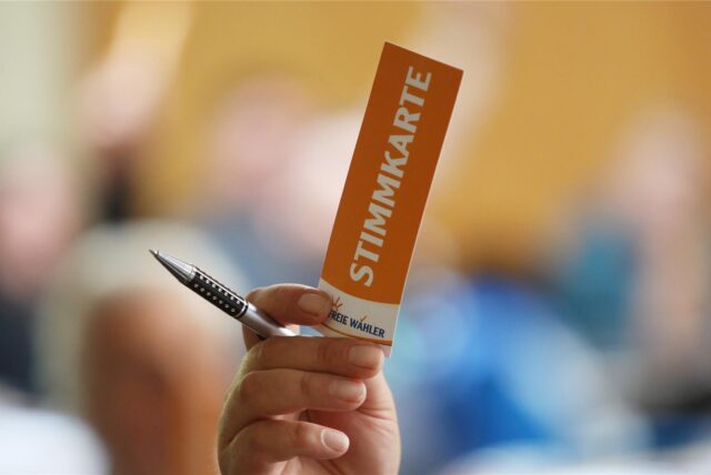 Ein Mann hält eine Stimmkarte der Freien Wähler in die Höhe. (Symbolbild)