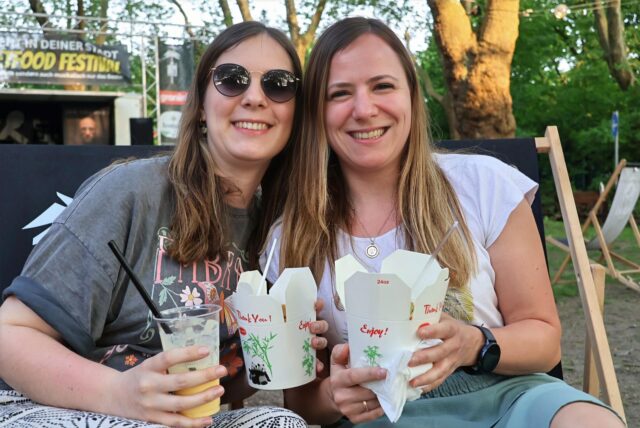 Menschen sitzen auf Bänken beim Streetfood-Festival in Dorsten