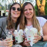 Menschen sitzen auf Bänken beim Streetfood-Festival in Dorsten
