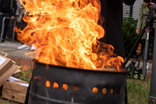 Flammen schlagen aus einer Feuertonne hoch.