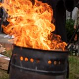 Flammen schlagen aus einer Feuertonne hoch.