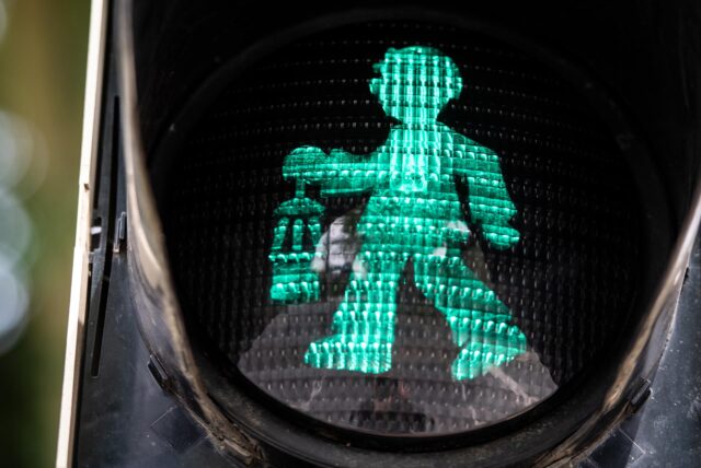 Ein Bergmann mit Grubenlampe leuchtet grün als Ampelmännchen.