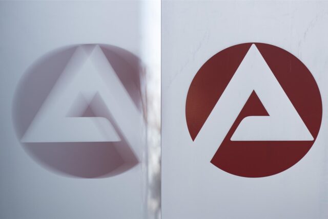Das Logo der Bundesagentur für Arbeit spiegelt sich in einer Scheibe.