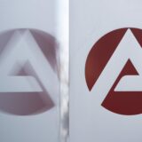 Das Logo der Bundesagentur für Arbeit spiegelt sich in einer Scheibe.