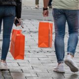 Menschen tragen am verkaufsoffenen Sonntag gut gefüllte Einkaufstüten durch die Fußgängerzone.