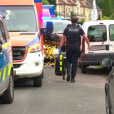 Ein Polizist geht durch die Lippestraße in Lünen, vorbei an Polizeifahrzeug und Krankenwagen.