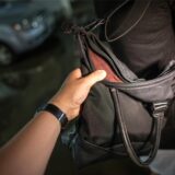 Ein Hand greift am 06.07.2012 in Dresden nach einer Geldbörse in einer Damenhandtasche.