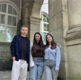 Drei Schüler vor einem Gebäude.
