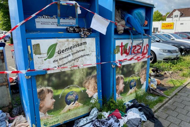 Altkleider-Container und Unrat hinter rot-weißem Flatterband an der Zechenstraße in Herten-Disteln.