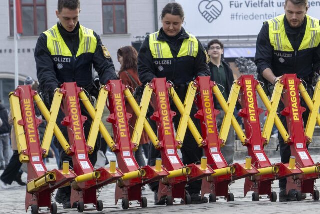 Polizisten bauen sogenannten Trucksperren auf.