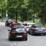 Autos parken auf der Straße, ein Auto weicht in den Gegenverkehr aus.