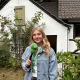 Vivien Caspers steht mit dem Mikro in der Hand vor der Museumsscheune im Alt-Marler Volkspark.