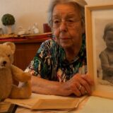 Jutta Uellenbeck sitzt an ihrem Esstisch, mit alten Fotos aus ihrer Kindheit.
