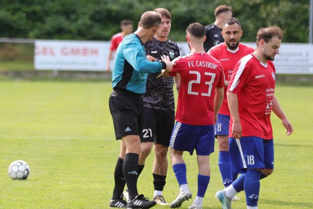 Mehrere Spieler diskutieren mit dem Schiedsrichter.