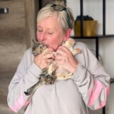 Conny Sander kuschelt mit zwei Kitten.