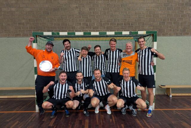 Ein Fußballteam steht vor einem Tor.