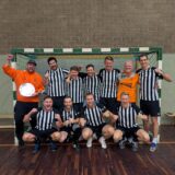 Ein Fußballteam steht vor einem Tor.