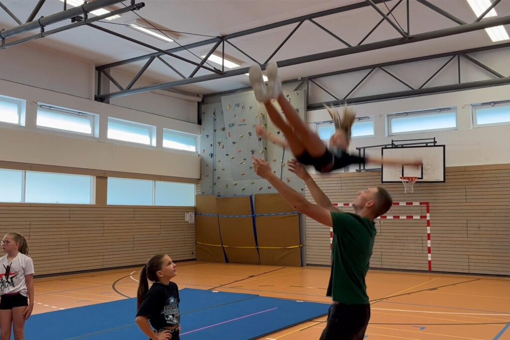 Mädchen trainieren mit einem Mann Cheerleading. Mädchen trainieren mit einem Mann Cheerleading.