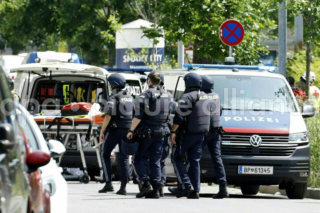 Einsatzkräfte der Polizei stehen in der Nähe des Tatorts an einer Grazer Schule. Ein Polizei-Großeinsatz ist in einer Grazer Schule in der Dreierschützengasse angelaufen. 