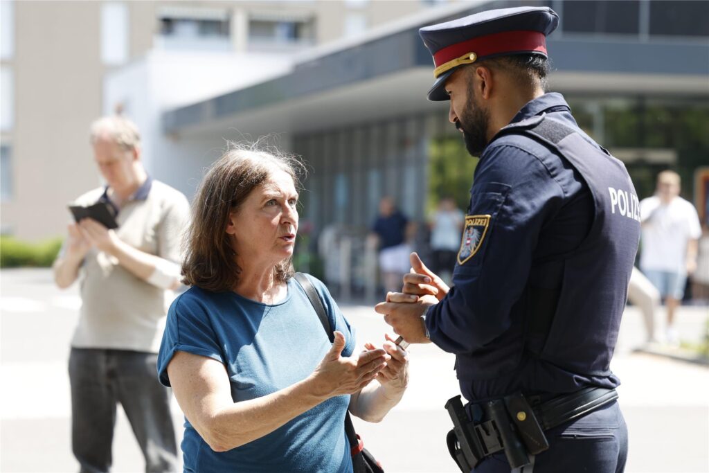 Die Grazer Bürgermeisterin Elke Kahr (KPÖ) und ein Polizist stehen in der Nähe des Tatorts in Graz. 