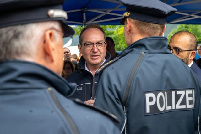Bundesinnenminister Alexander Dobrindt (M) unterhält sich bei seinem Besuch der Grenzkontrollstelle Kiefersfelden an der A 93 mit Polizeibeamten.