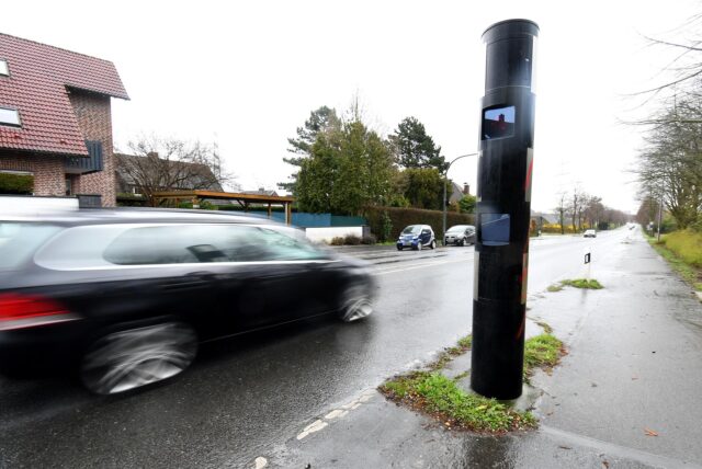 Ein schwarzes Auto fährt an der Radarsäule der Stadt Herten an der Hertener Straße vorbei.