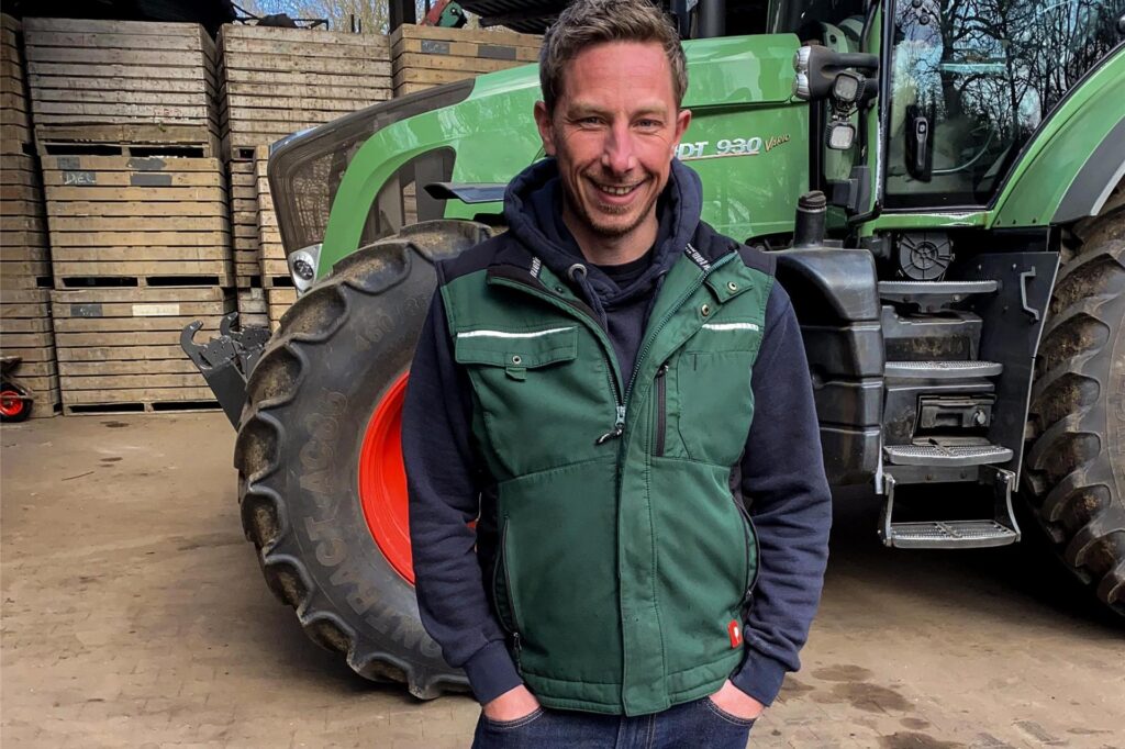 Andreas, Teilnehmer von Bauer sucht Frau 2025, steht vor einem Traktor.