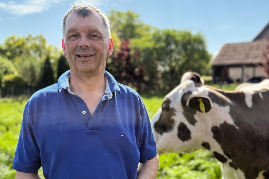 Johann, Teilnehmer von Bauer sucht Frau 2025, steht neben einer Kuh.